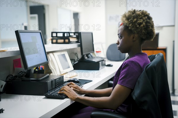 Black nurse using computer