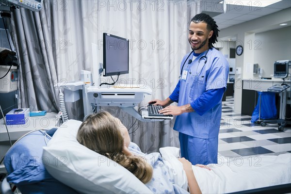 Nurse talking to patient in hospital bed