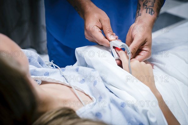 Nurse placing finger monitor on patient