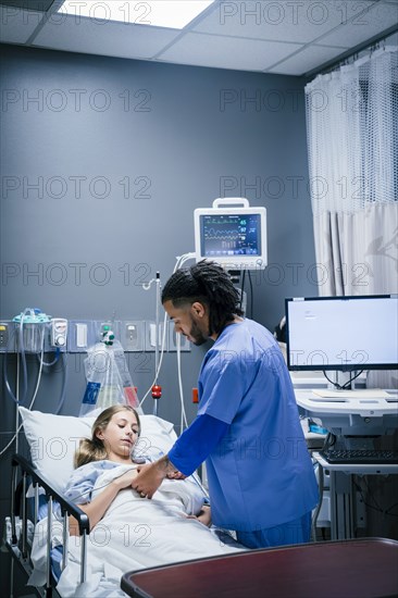 Nurse holding hand of patient in hospital