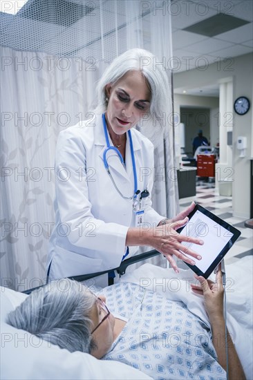 Doctor showing digital tablet to patient