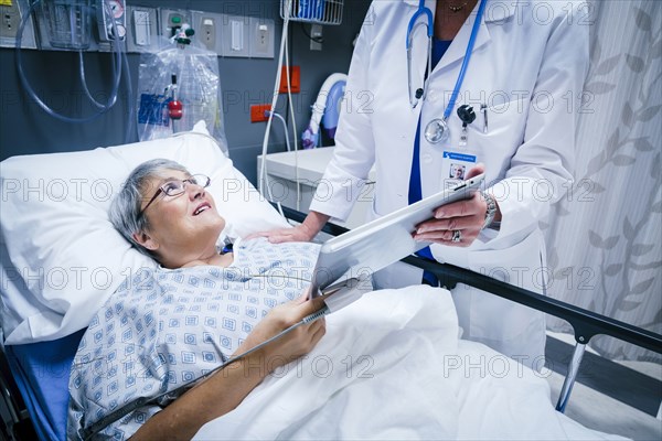 Doctor showing digital tablet to patient