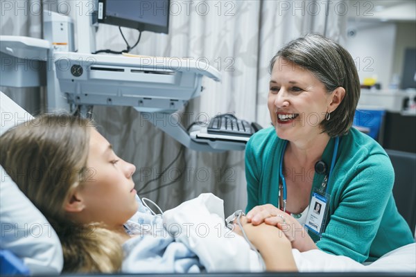 Caucasian doctor comforting patient in hospital bed