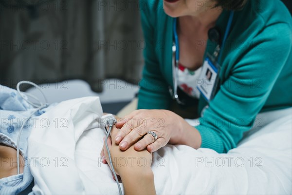 Caucasian doctor comforting patient in hospital bed