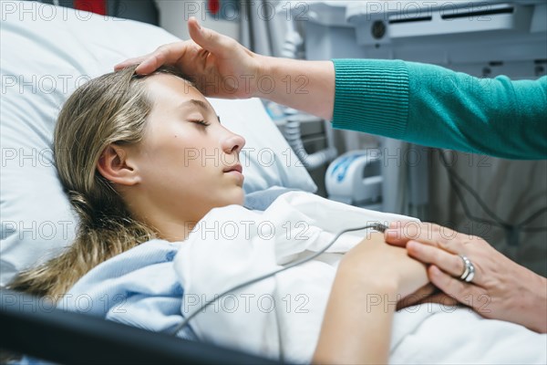 Caucasian doctor comforting patient in hospital bed