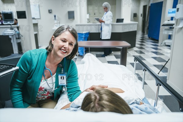 Caucasian doctor comforting patient in hospital bed