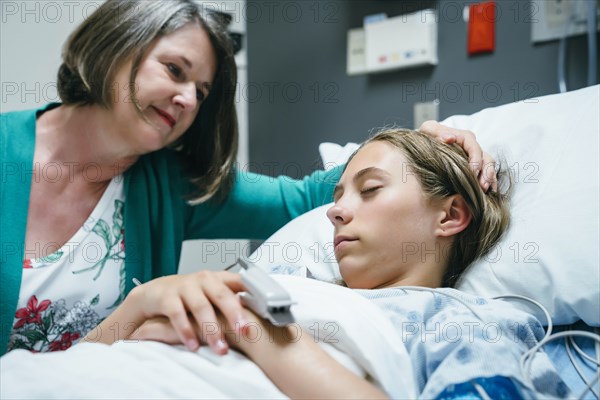 Caucasian mother comforting daughter in hospital