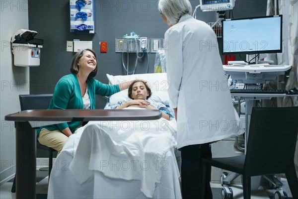 Caucasian doctor talking to mother and daughter in hospital