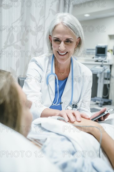 Caucasian doctor comforting girl in hospital bed