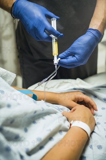 Nurse injecting medicine into tube of patient