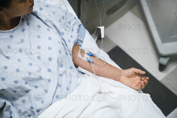 Tubes in arms of patient in hospital bed