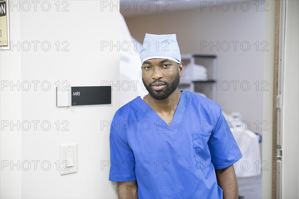 Portrait of confident black nurse near MRI sign