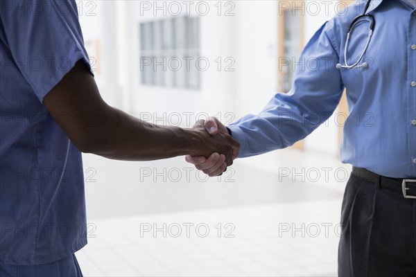 Close up of doctor and nurse shaking hands