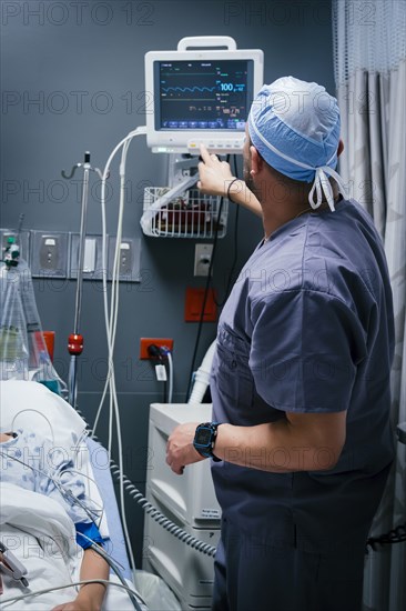 Nurse pressing button on monitor for patient