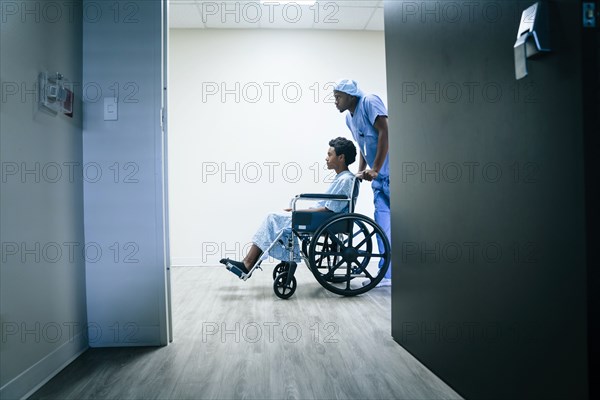 Nurse pushing boy in wheelchair