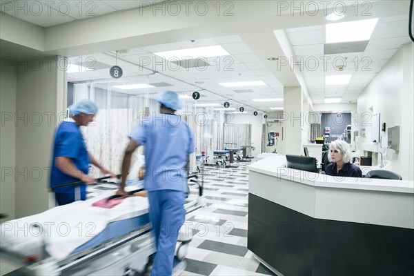 Doctors pushing patient in hospital gurney