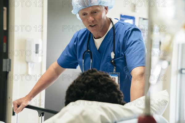 Doctor talking to boy in hospital bed