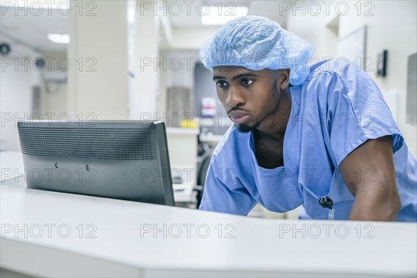 Black doctor using computer in hospital