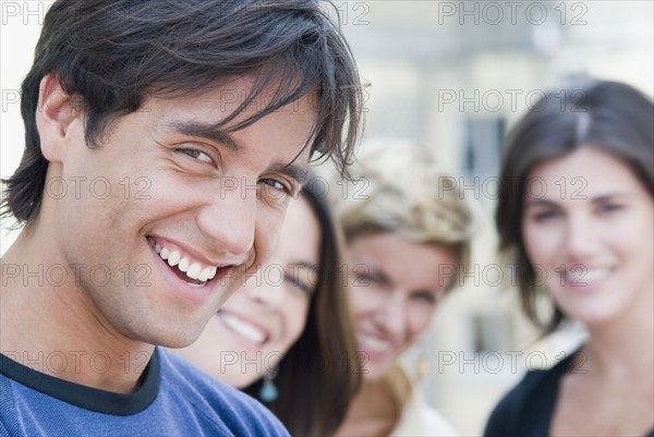 Hispanic man smiling with friends in background