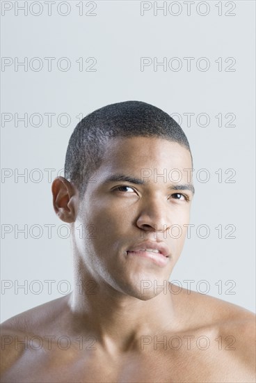 Bare-chested African man biting lip