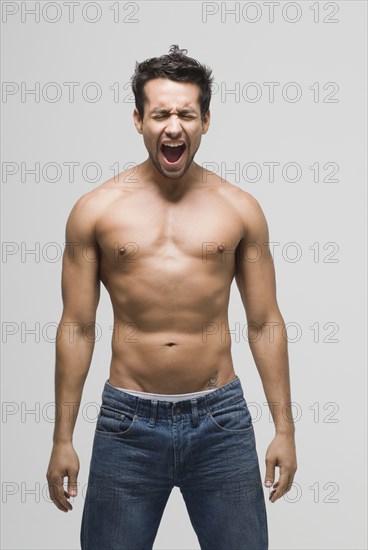 Bare-chested Hispanic man yelling