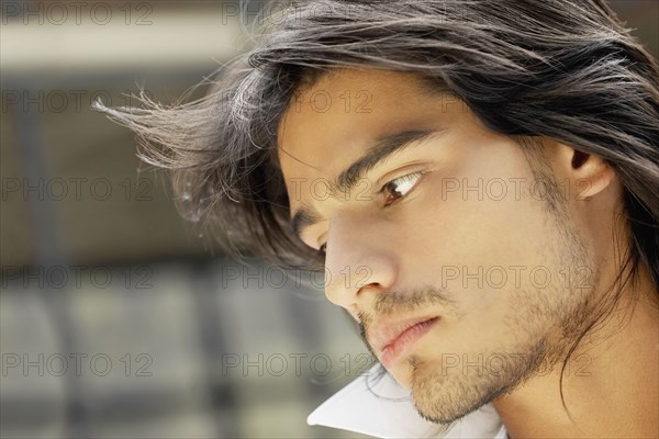 Close up of young Hispanic man looking down