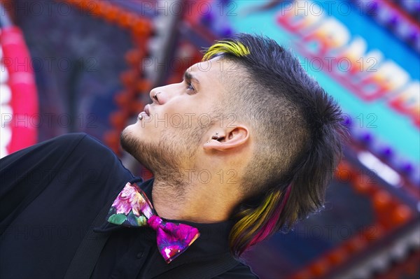 Low angle view of young Hispanic male punk with mohawk and bowtie
