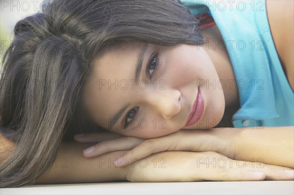 Hispanic girl resting head on hands