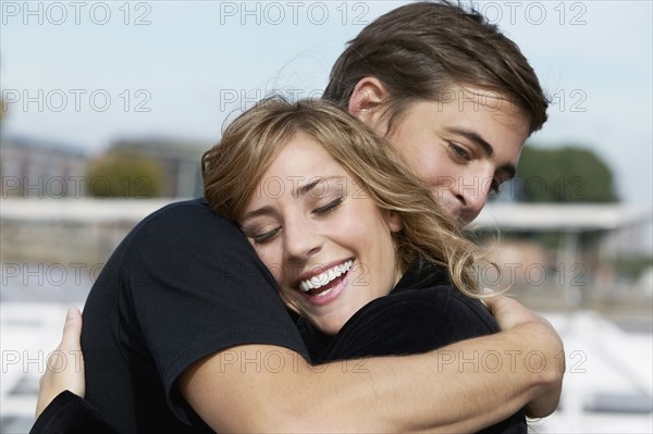 Young Hispanic couple hugging indoors