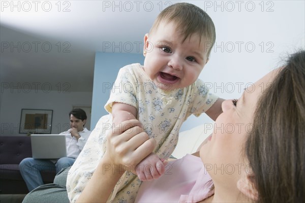 Hispanic mother playing with baby