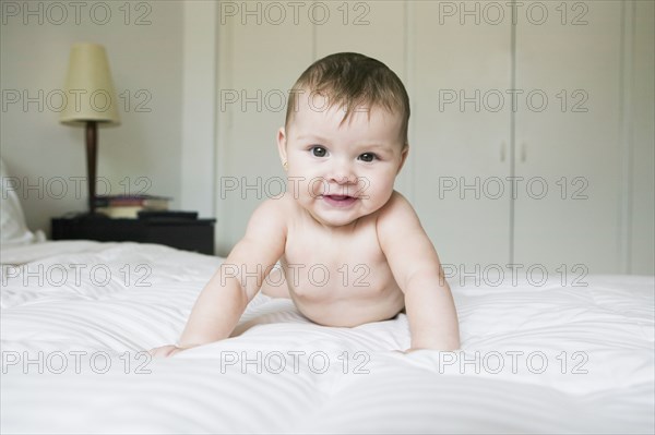 Hispanic baby laying on bed