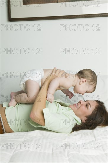 Hispanic mother playing with baby