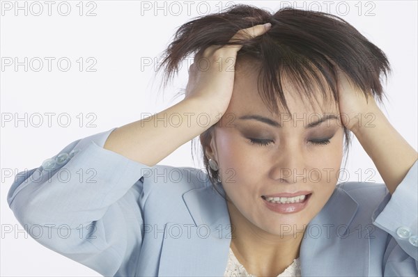 Asian businesswoman with hands in hair