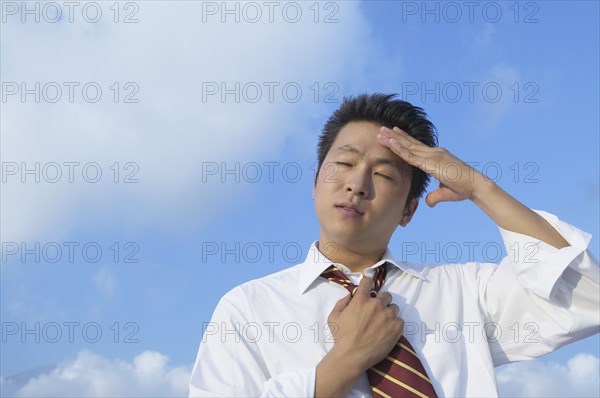 Asian businessman rubbing forehead