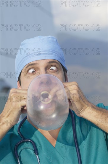 Hispanic doctor blowing up condom
