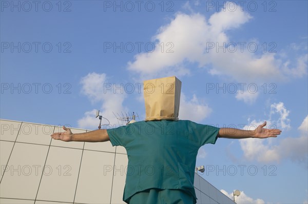 Hispanic male doctor wearing bag over head