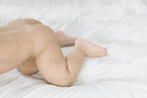 Nude Hispanic baby crawling