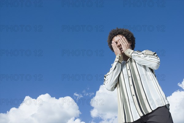 Mixed Race man with hands on face