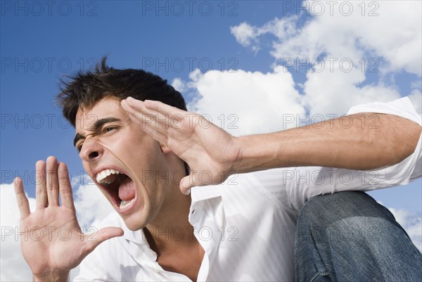 Man yelling with hands up