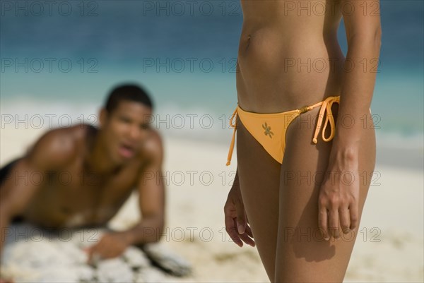 Hispanic man looking at woman on beach