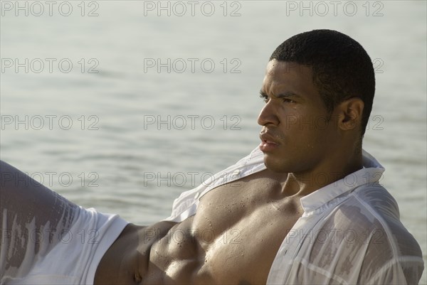 Hispanic man in wet clothing at beach