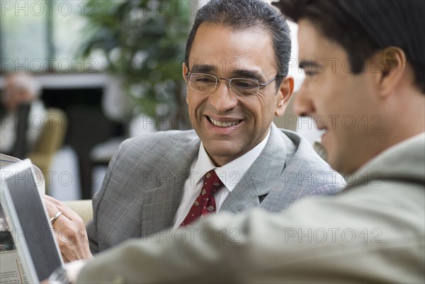 Hispanic businessmen looking at laptop