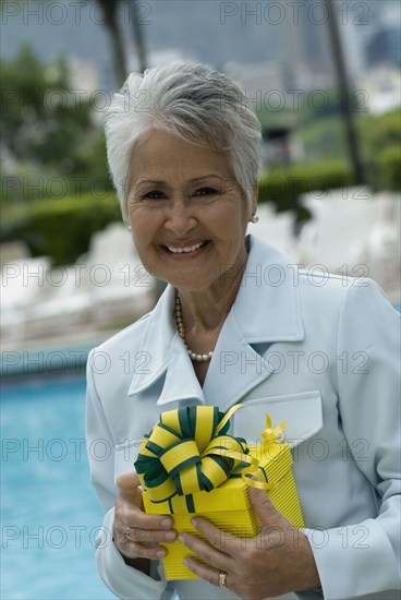 Senior Hispanic woman holding gift