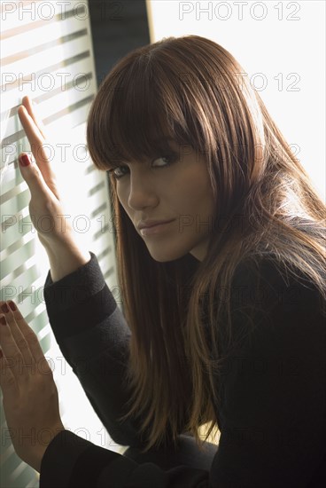 Young woman with hands on glass door