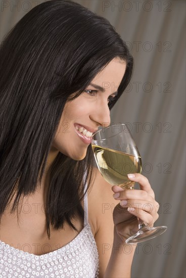 Hispanic woman drinking wine