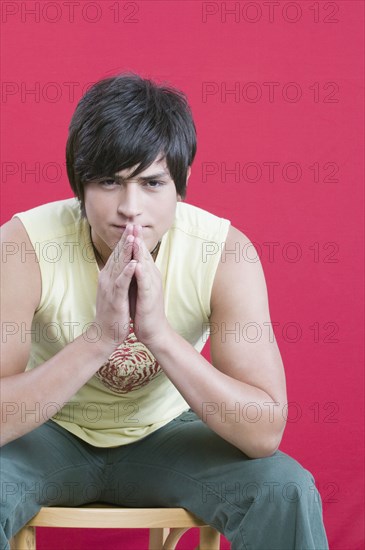 Young Hispanic man sitting in chair