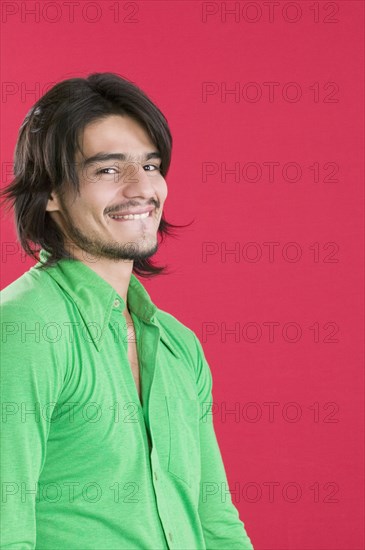 Young Hispanic man biting lip