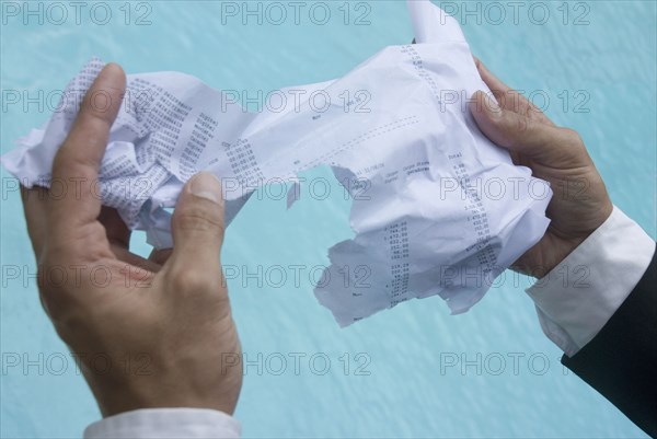 Hispanic businessman holding wet paperwork