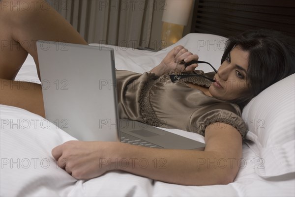 Hispanic woman looking at laptop