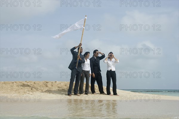 Multi-ethnic businesspeople with flag at beach